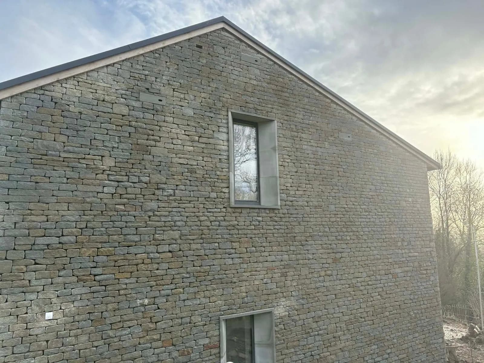 The finished gable in grey green Forest stone, laid on a dry bed, Malvern