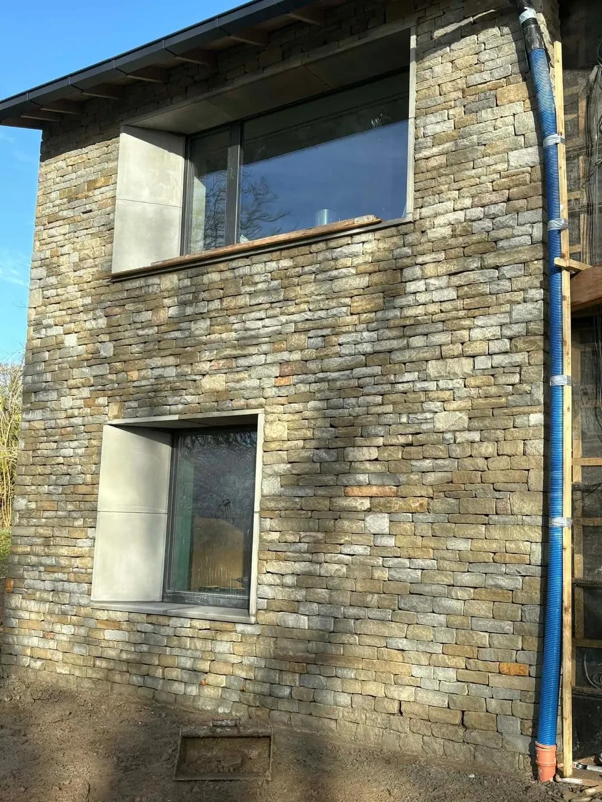 Grey green Forest stone and stone window surrounds on a house in Malvern, by RH Stonework & Masonry